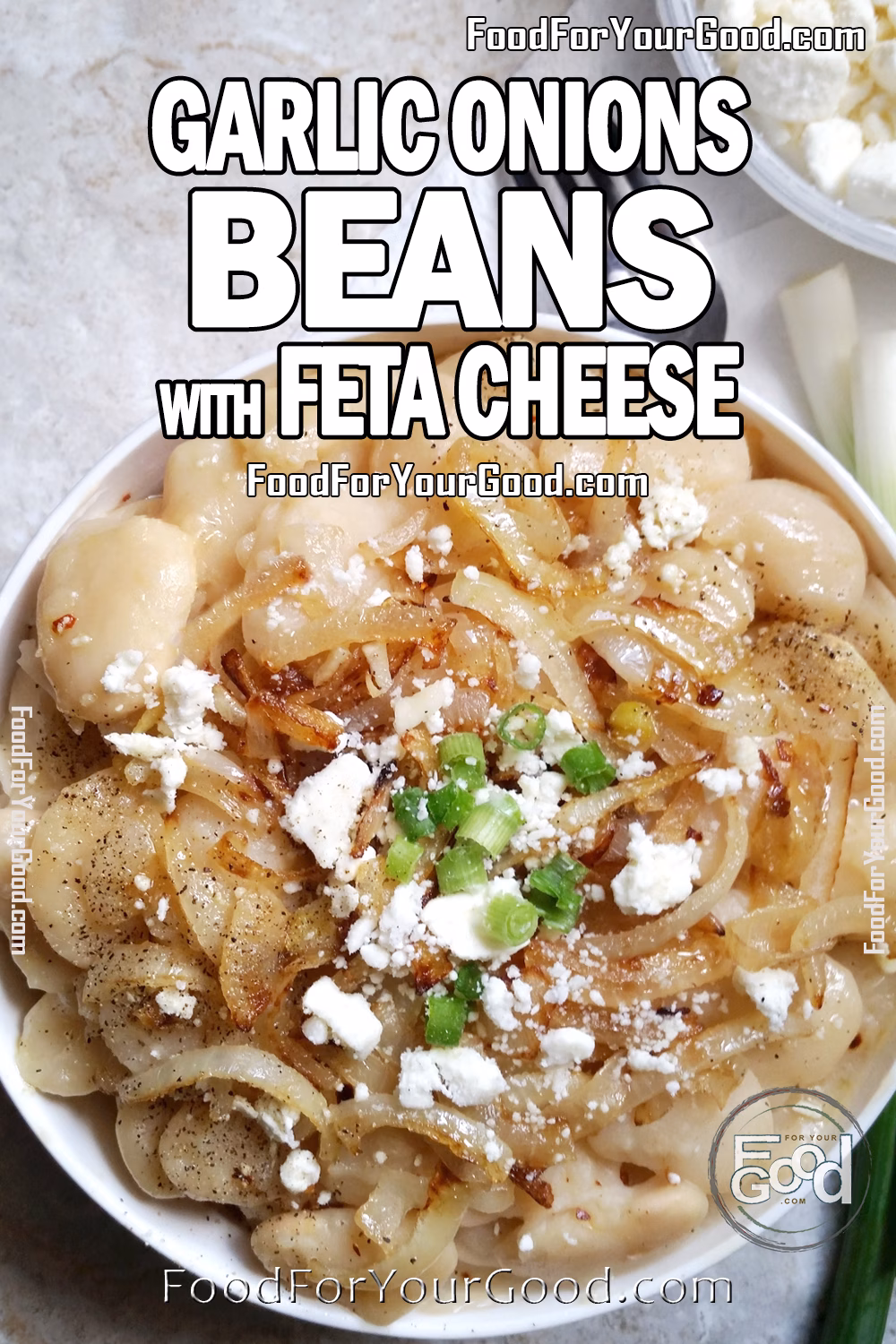White beans topped with caramelized onions, garlic, crumbled feta cheese, and green onion garnish served in a white bowl on marble surface.