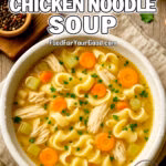 Homemade Chicken Noodle Soup with egg noodles, carrots, celery, and shredded chicken served in a rustic white bowl, topped with fresh parsley. Recipe available on FoodForYourGood.com for cozy and delicious meal inspiration.