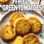 Golden crispy Southern Fried Green Tomatoes served on a rustic white plate with a side of creamy remoulade. A classic Southern dish with a crunchy cornmeal coating. Recipe from FoodForYourGood.com