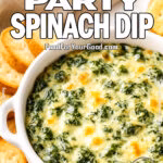 Baked 3-Ingredient Party Spinach Dip served in a white dish with toasted baguette slices and crackers on a wooden board