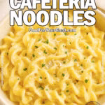 A bowl of creamy cafeteria-style egg noodles topped with Parmesan cheese and parsley, served in a beige ceramic bowl on a marble surface.
