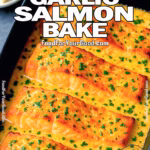 Creamy Garlic Butter Baked Salmon in black dish topped with fresh parsley on marble background