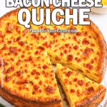 A golden-brown crustless bacon cheese quiche with a slice cut out, surrounded by fresh chives, bacon, and cheddar cheese on a white marble background.