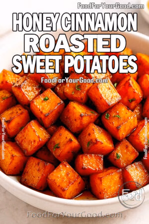 A bowl of honey cinnamon roasted sweet potatoes, golden and caramelized, served in a white bowl on a light marble surface with a dish of honey in the background.