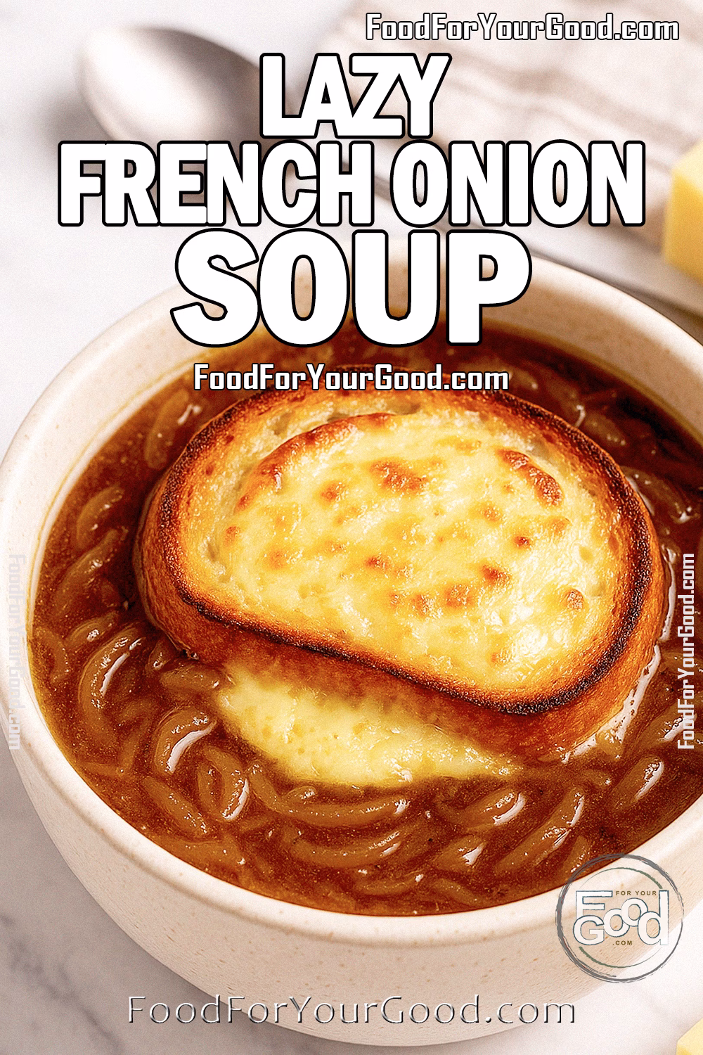 Lazy French Onion Soup with Melty Cheese Toast – FoodForYourGood.com A bowl of Lazy French Onion Soup topped with golden cheese toast, served on a marble countertop with a spoon and cheese blocks in the background.