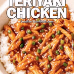 A bowl of slow cooker teriyaki chicken over rice, garnished with green onions and sesame seeds, styled with a fork and fresh chives on a marble surface.