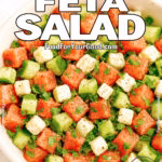 Watermelon Feta Salad in a rustic bowl with mint, lime, and cucumber on white marble.