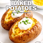 Two crispy air-fried baked potatoes topped with cheddar cheese, sour cream, and chives on a white plate.