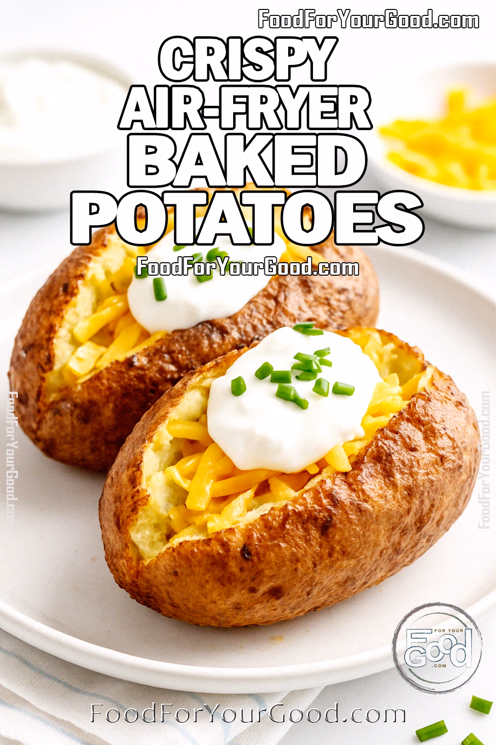 Crispy Air-Fryer Baked Potatoes with Cheddar and Chives – FoodForYourGood.com Two crispy air-fried baked potatoes topped with cheddar cheese, sour cream, and chives on a white plate.