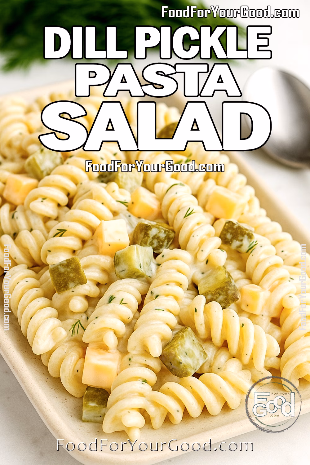 Dill Pickle Pasta Salad with Cubed Cheddar Creamy dill pickle pasta salad with cubed cheddar cheese and chopped pickles served on a white rectangular plate.