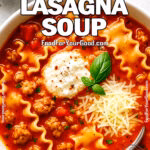 A bowl of Easy Lasagna Soup topped with ricotta, Parmesan, and basil, served with a spoon on a light background.