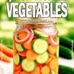 A glass mason jar filled with homemade quick-pickled vegetables including carrots, cucumbers, and onions, set against a soft green outdoor background.