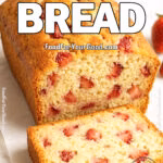 Sliced strawberry bread loaf with visible fresh strawberry chunks on a marble surface.