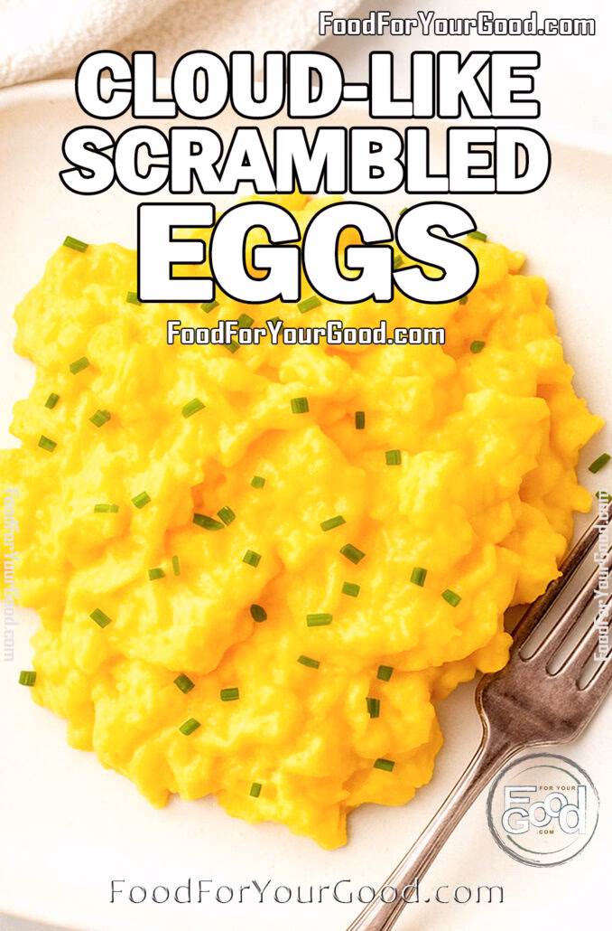 Cloud-Like Scrambled Eggs Cloud-Like Scrambled Eggs served on a white square plate with fork and chives on top, on marble background