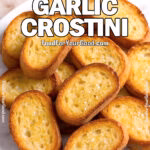 A pile of golden, crispy garlic crostini on a white marble plate, perfect as an appetizer base.