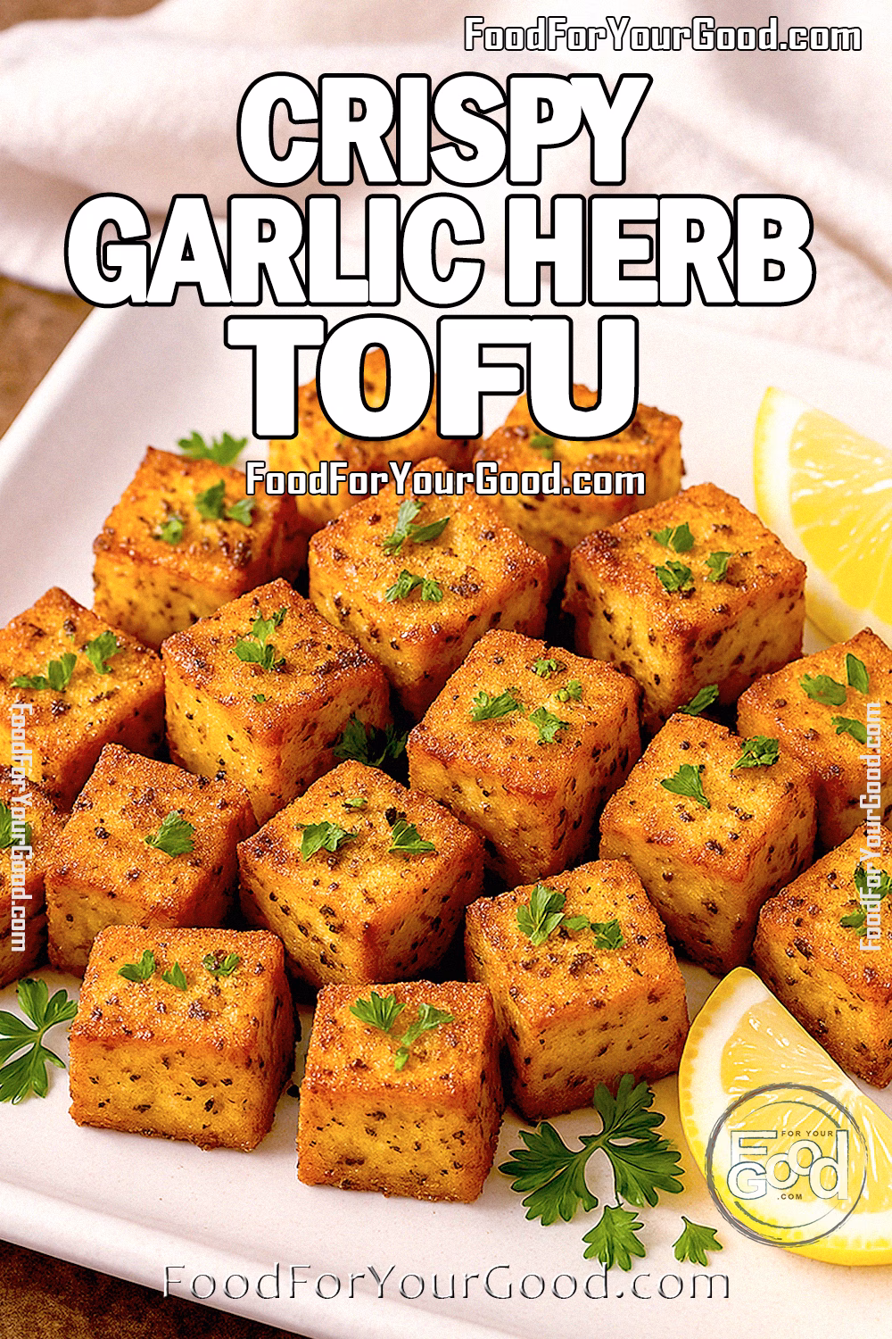 Crispy Garlic Herb Tofu Recipe on FoodForYourGood.com Golden crispy garlic herb tofu cubes served on a square white plate with lemon wedges and fresh parsley on a brown marble background.