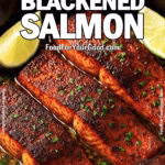 Blackened salmon fillets in garlic butter lime sauce with fresh lime wedges in a cast-iron skillet on marble