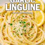 Lemon Garlic Linguine served in a white square bowl with lemon wedges and Parmesan on marble.