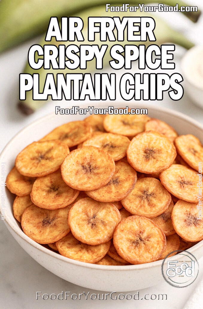 A beige ceramic bowl filled with air fryer crispy spice plantain chips, seasoned golden-brown and served on a white marble countertop with fresh green plantains and dipping sauce in the background.
