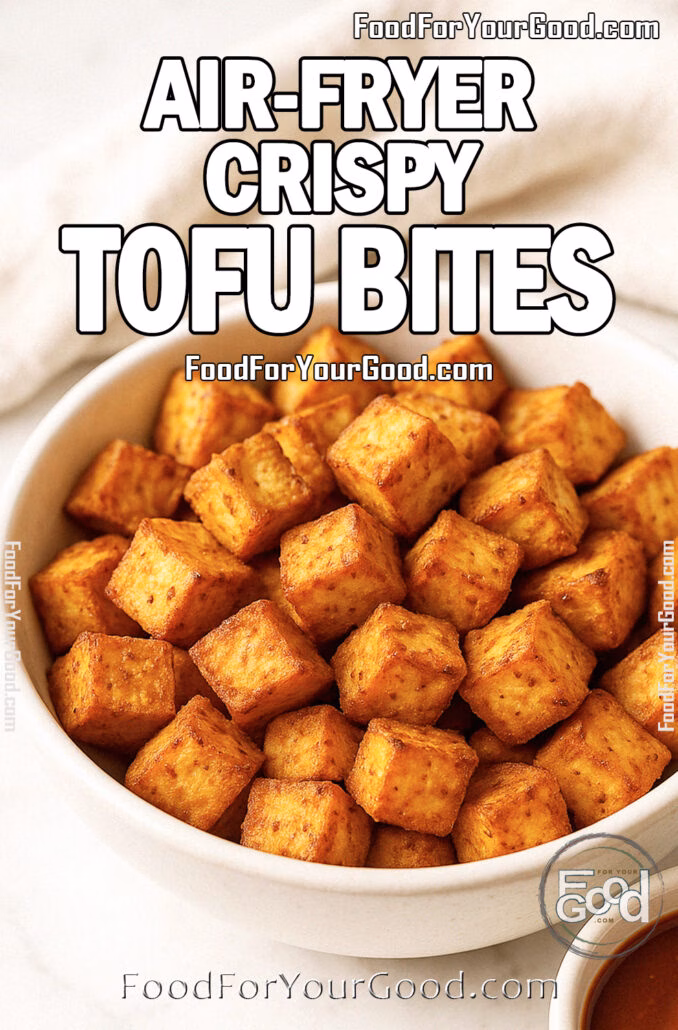 Crispy golden air-fried tofu cubes in a white bowl with dipping sauce on marble surface