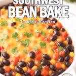 Cheesy Southwest Bean Bake in a white ceramic dish on a marble countertop, topped with golden melted cheese extending close to the edges, with a section near the rim left uncovered to reveal black beans, corn, and red peppers inside, garnished with fresh cilantro.