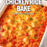 Cheesy Tomato Chicken Rice Bake in a white ceramic baking dish topped with melted cheddar and parsley.