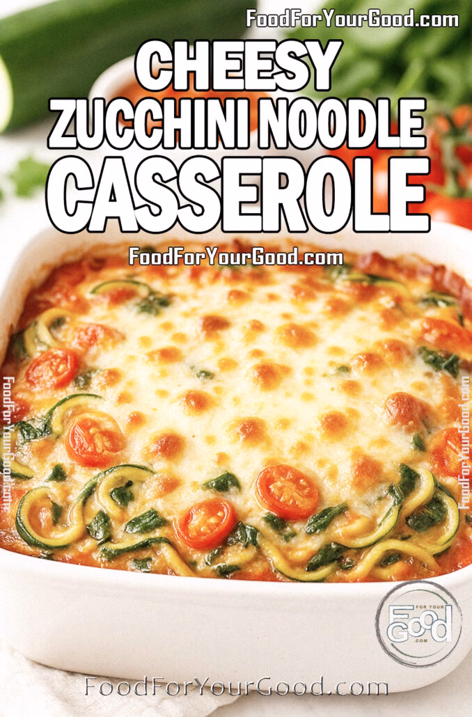 Cheesy Zucchini Noodle Casserole A freshly baked Cheesy Zucchini Noodle Casserole in a white square dish, topped with golden melted mozzarella and Parmesan, surrounded by fresh zucchini, tomatoes, spinach, and marinara sauce on a white marble countertop.