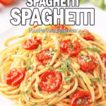A plate of Cherry Tomato Spaghetti served on a white square upscale plate, topped with roasted cherry tomatoes, chopped basil, Parmesan, and pine nuts on a marble background.
