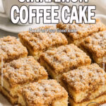 A luxurious white tray holds a freshly baked sour cream cinnamon coffee cake sliced into squares, dusted with powdered sugar, next to a white cup of black coffee on a marble countertop.