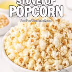 A large white marble bowl filled with fluffy golden stovetop popcorn, lightly drizzled with butter, on a marble countertop with salt and kernels blurred in the background.