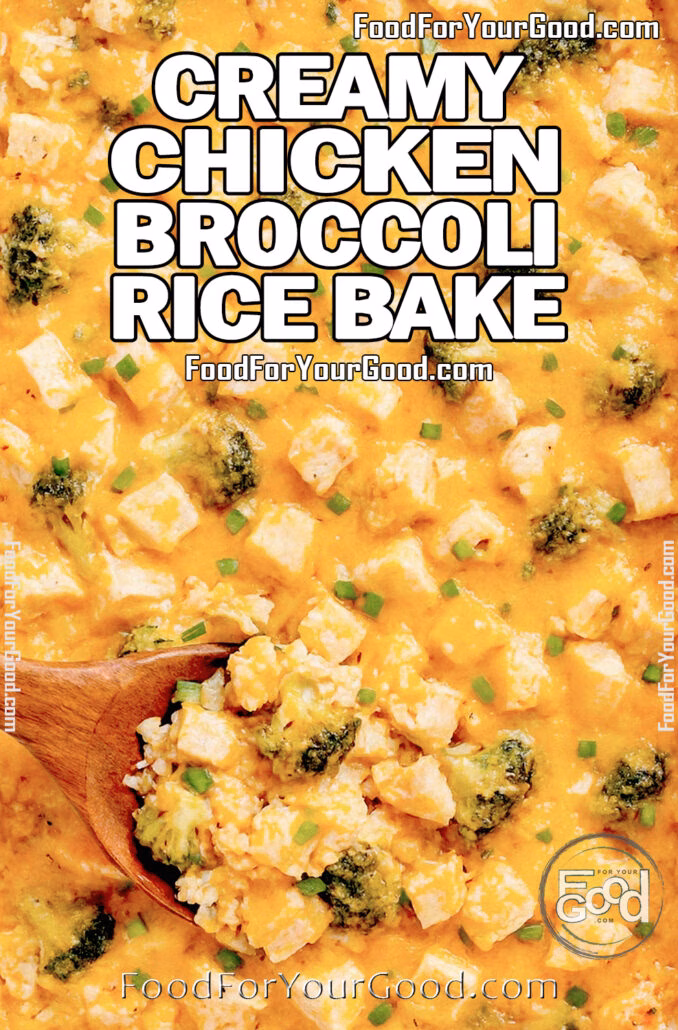 Overhead view of creamy chicken broccoli rice casserole in a white rectangular baking dish, topped with melted cheddar cheese, diced chicken, broccoli florets, and chopped green onions, with a wooden spoon serving a portion.