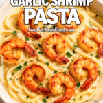 Close-up of creamy garlic shrimp pasta with crispy shrimp in white bowl on marble countertop