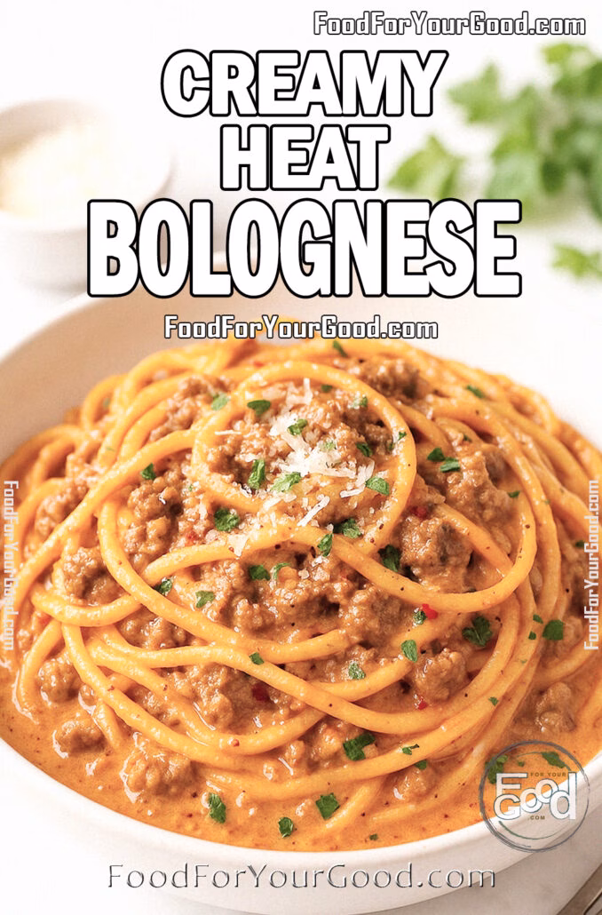 Creamy Heat Bolognese Creamy Heat Bolognese pasta served in a white ceramic bowl, coated in a rich spicy tomato cream sauce, garnished with fresh basil and Parmesan on a white marble countertop.
