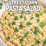 Creamy Mexican Street Corn Pasta Salad with charred corn, cotija, and cilantro served in a white bowl on marble.