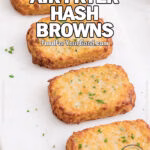 Crispy Air Fryer Hash Browns arranged on a white marble tray, golden and rustic, topped with fresh parsley. Styled with whole potatoes and a white towel on a marble countertop for an upscale, homemade look.