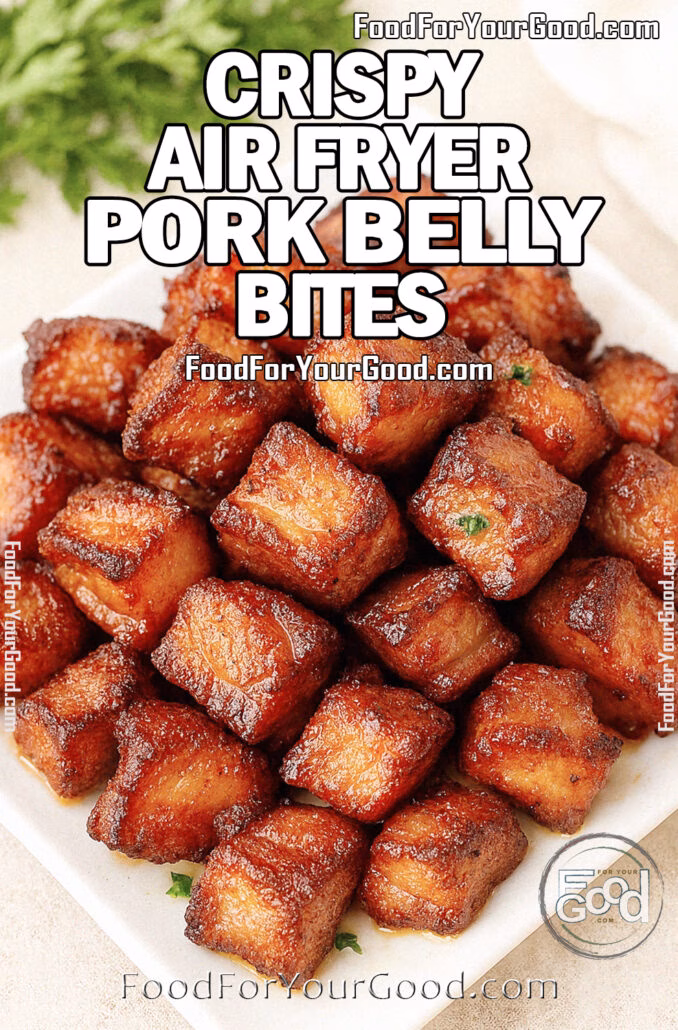 Crispy Air Fryer Pork Belly Bites Juicy and crispy Air Fryer Pork Belly Bites on a white square plate, golden brown with caramelized edges and glossy texture, garnished with parsley and styled with herbs and a towel in the background on FoodForYourGood.com