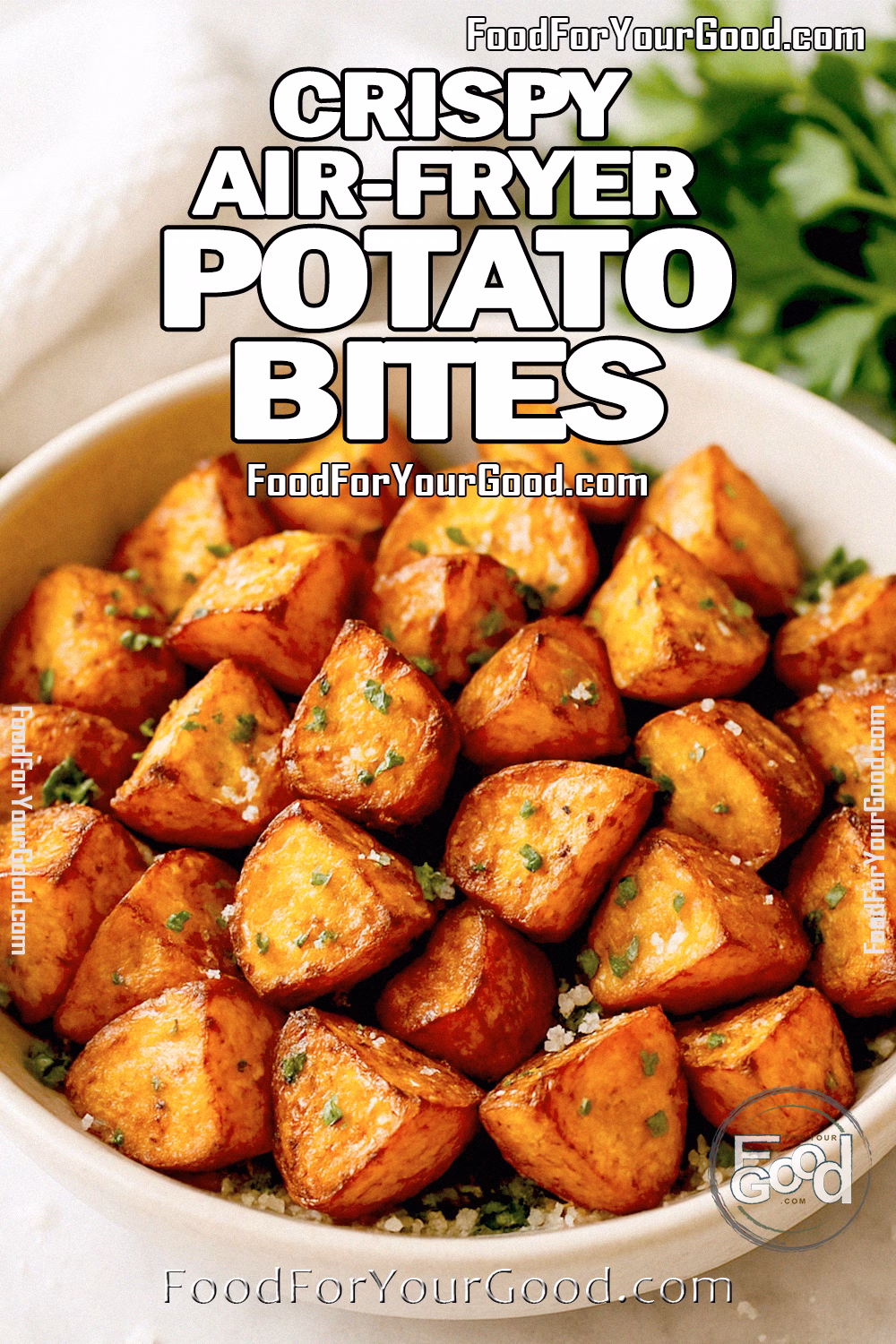 A bowl of Crispy Air-Fryer Potato Bites garnished with parsley and Parmesan on a marble countertop.