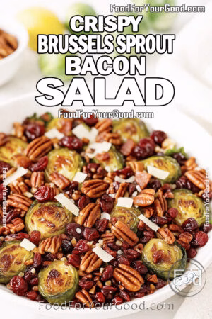 Crispy Brussels Sprout Bacon Salad with bacon, toasted pecans, dried cranberries, and Parmesan shavings, served in a white bowl on a marble countertop.