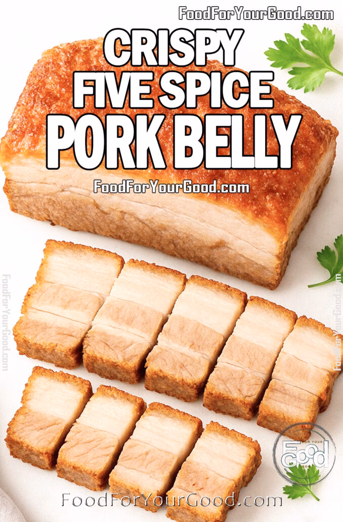 Whole Crispy Five Spice Pork Belly slab with golden crackling skin, partially sliced into thick pieces, displayed on a white marble cutting board with parsley garnish for FoodForYourGood.com