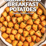 Crispy Garlic Herb Breakfast Potatoes in a cast iron skillet on white marble with a wooden spoon