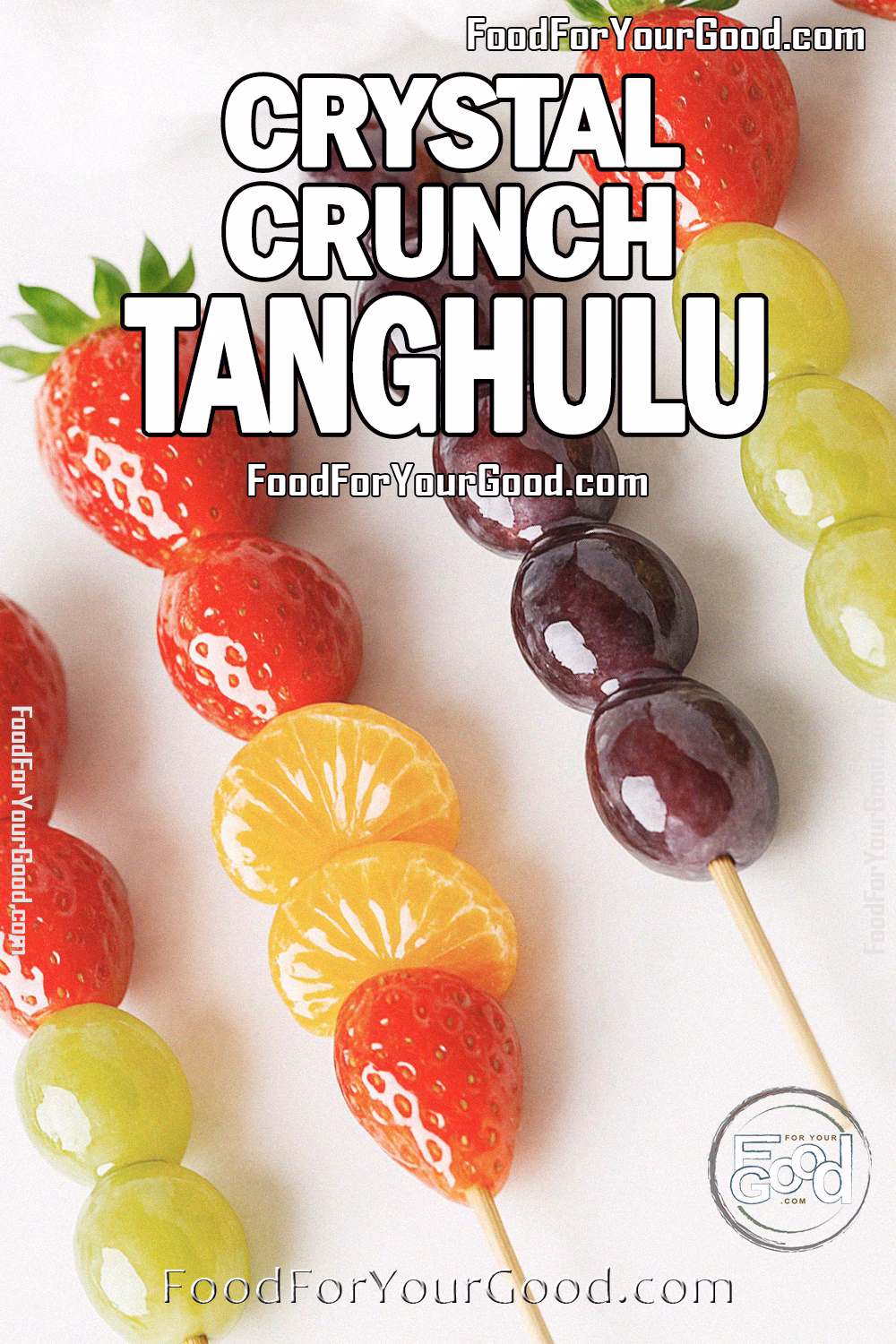 Crystal Crunch Tanghulu Candied Fruit Recipe - FoodForYourGood.com Crystal Crunch Tanghulu skewers with glossy candied grapes, strawberries, and mandarin orange segments arranged on a white marble countertop with a soft blurred towel in the background.