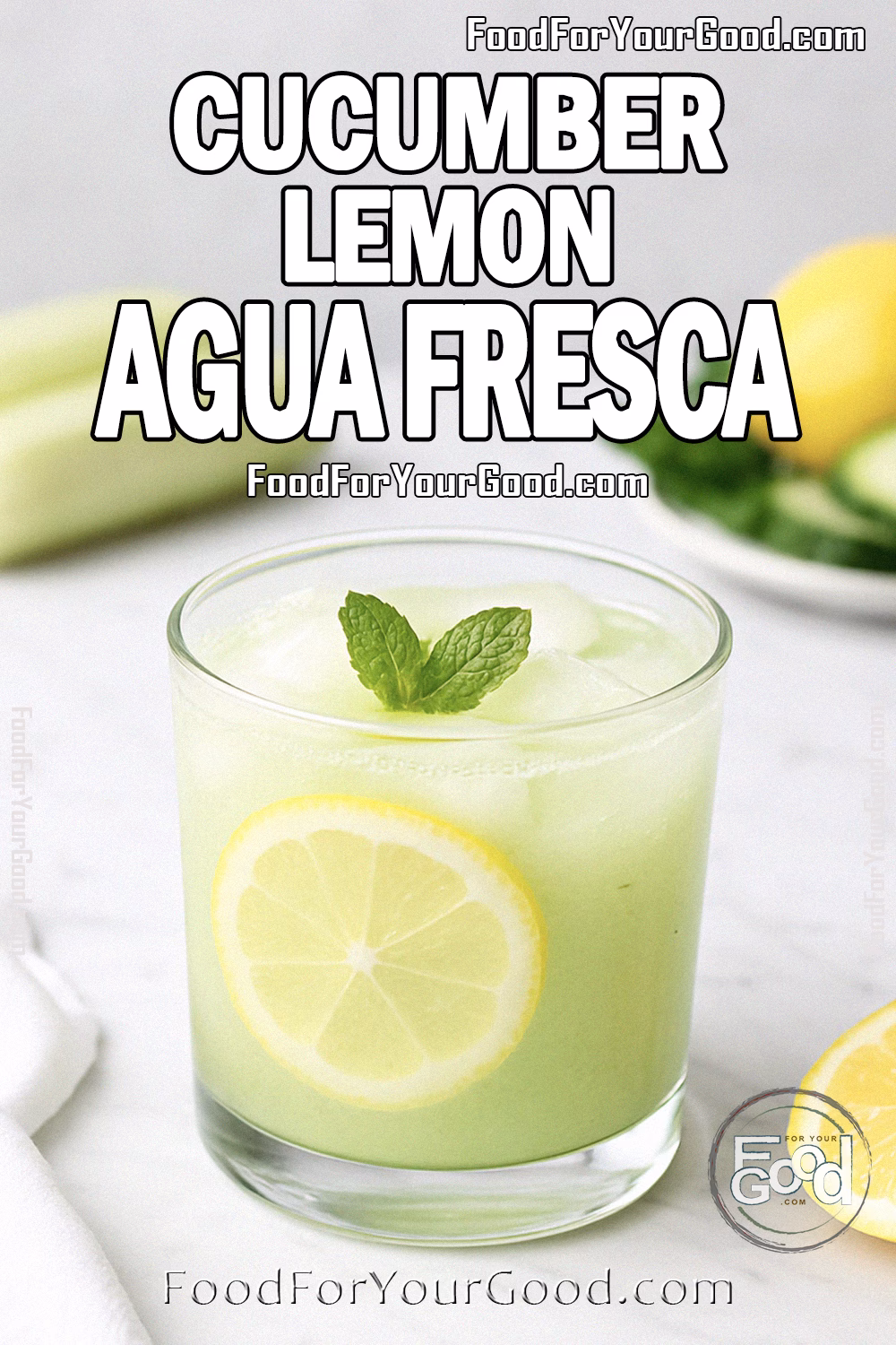 Cucumber Lemon Agua Fresca Recipe – FoodForYourGood.com A short, wide glass of Cucumber Lemon Agua Fresca with ice, lemon slice, and a mint sprig on a white marble countertop.