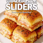 Golden Dijon Glazed Ham Sliders stacked on a plate with melted cheese and smoked ham