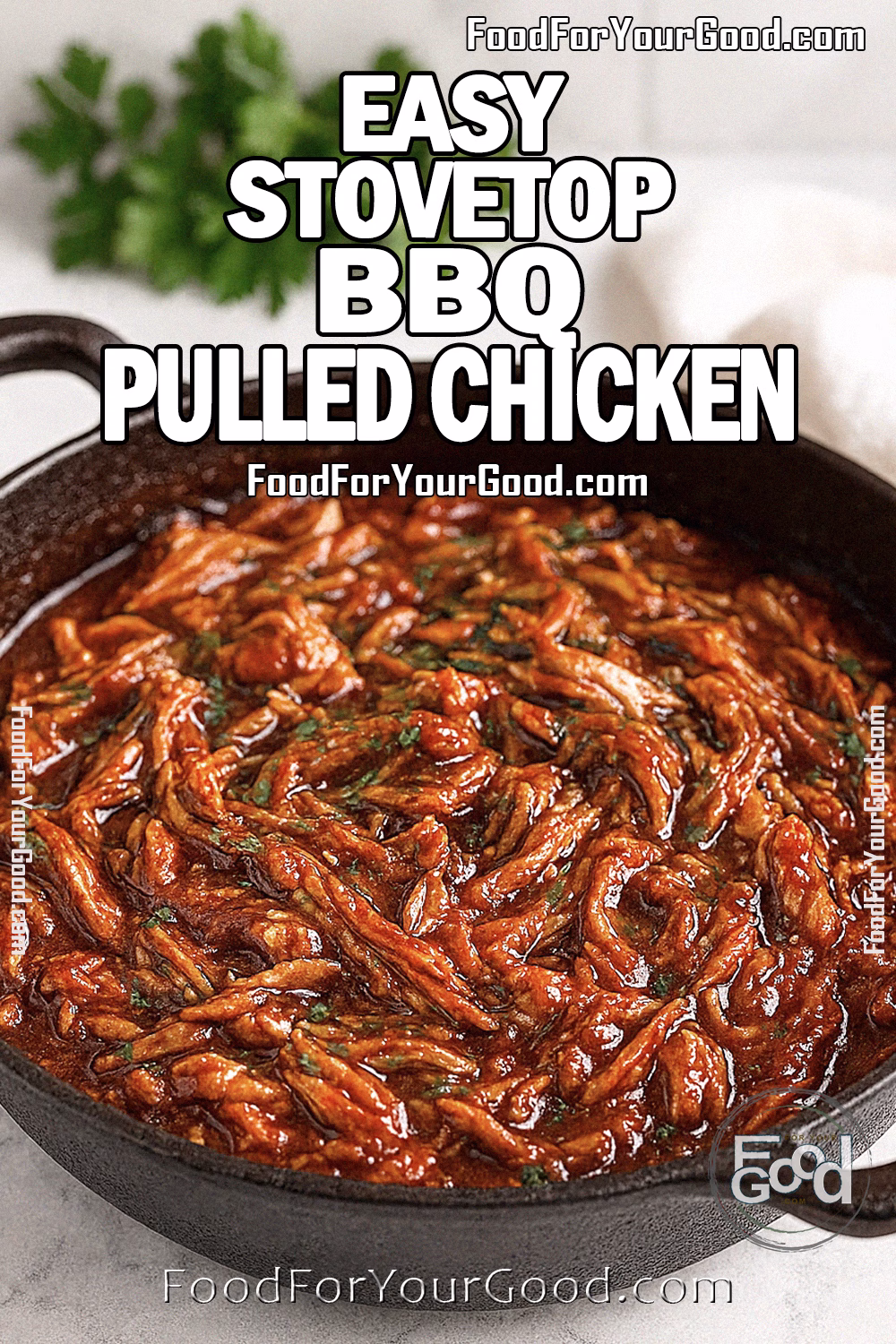 Easy Stovetop BBQ Pulled Chicken with Parsley | FoodForYourGood.com Easy Stovetop BBQ Pulled Chicken in a black cast-iron skillet, generously garnished with fresh chopped parsley, sitting on a white marble countertop with a soft linen towel and blurred herbs in the background, for FoodForYourGood.com