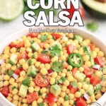 A rustic bowl of Fiesta Corn Salsa with corn, avocado, tomatoes, jalapeño, red bell pepper, and cilantro on a marble countertop.