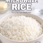 Fluffy Microwave Rice served in a white bowl on a marble countertop with butter, parsley, and salt in the background.