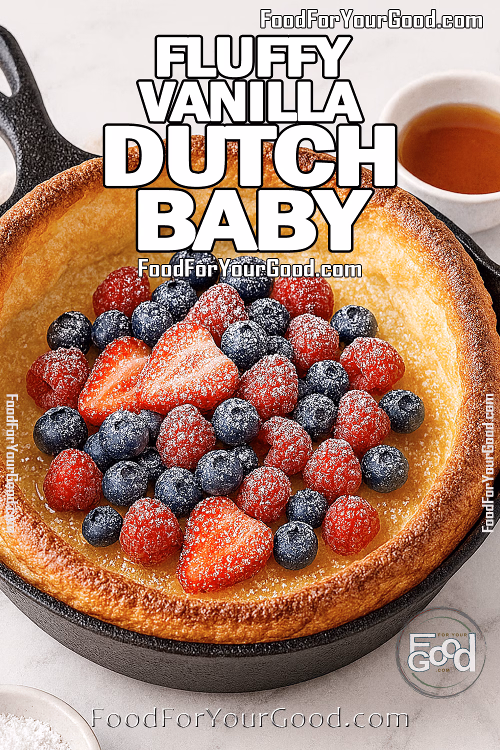 Fluffy Vanilla Dutch Baby with Berries and Maple Syrup | FoodForYourGood.com Fluffy Vanilla Dutch Baby in a cast-iron skillet with tall golden edges, topped with fresh strawberries, blueberries, raspberries, powdered sugar, and lightly drizzled maple syrup.