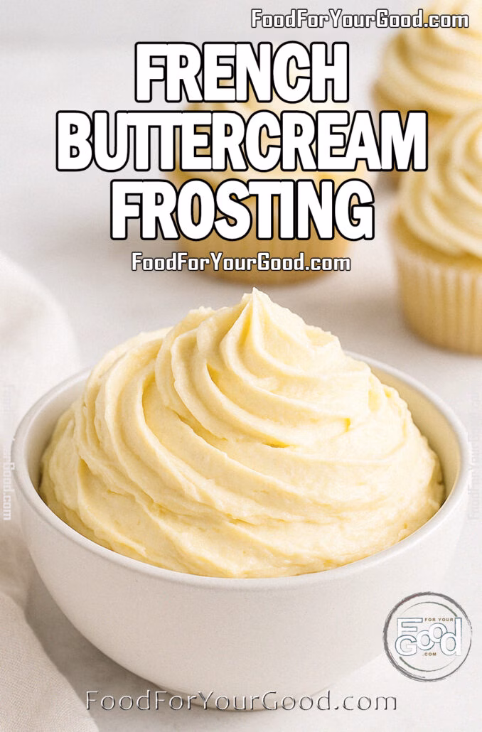 French Buttercream Frosting A white bowl filled with smooth, golden French Buttercream Frosting, with vanilla cupcakes topped with the same frosting in the background on a white marble surface.