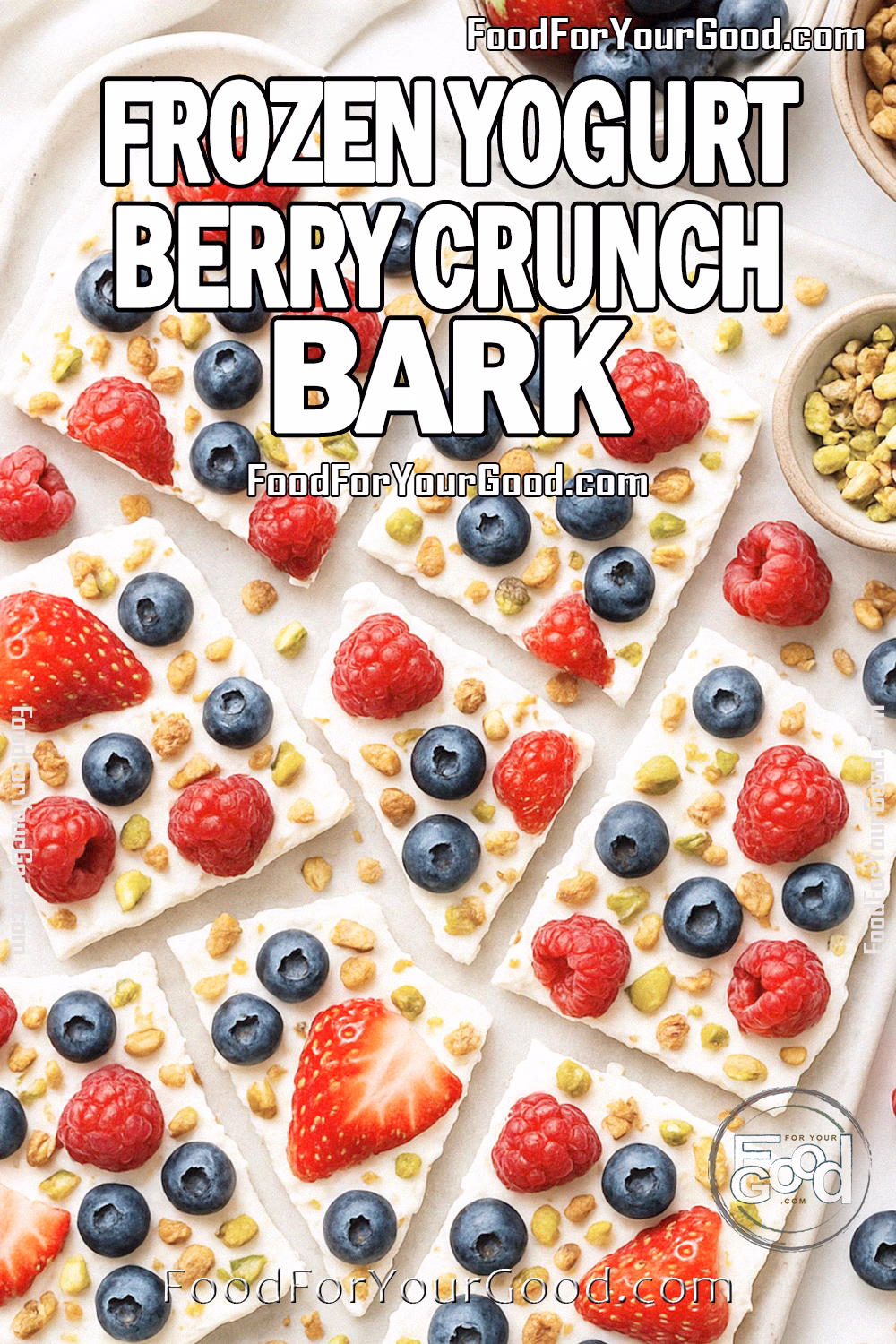 Frozen Yogurt Berry Crunch Bark Recipe on FoodForYourGood.com Frozen Yogurt Berry Crunch Bark broken into rustic pieces on a marble tray with parchment paper, surrounded by bowls of fresh berries, granola, and pistachios.
