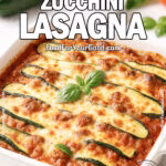 A freshly baked Garden-Fresh Zucchini Lasagna in a white ceramic dish, topped with golden melted cheese and zucchini slices, garnished with basil, set on a white marble background with fresh zucchini, basil, tomato, parmesan, and a white towel in the background.